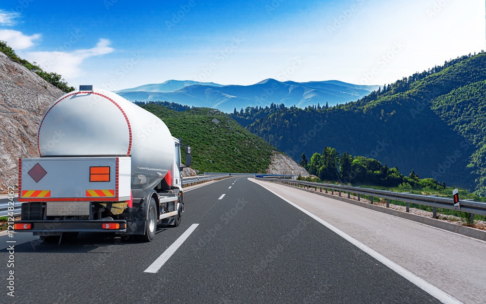 Fuel truck on a picturesque road. A silver tank truck transports fuel.