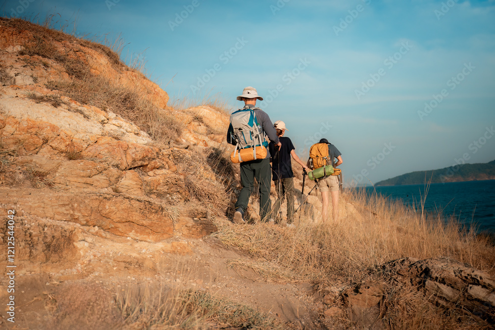 Obraz premium Hikers or explorers on journey carrying backpack, trekking poles looks into the distance observing and possibly guide trekking and trail exploration holiday ecotourism concept. 