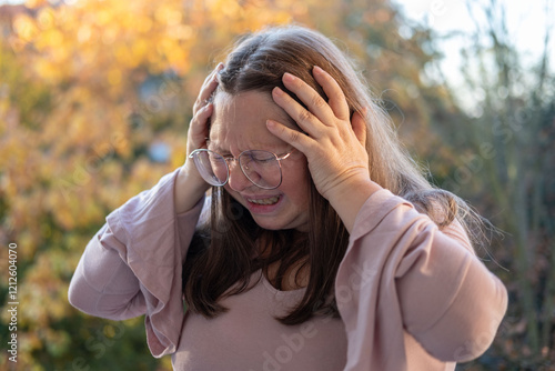 mature woman suffering from severe migraine, holding head in pain, pained expression, migraine attack, close-up distressed face, emotional struggle photo