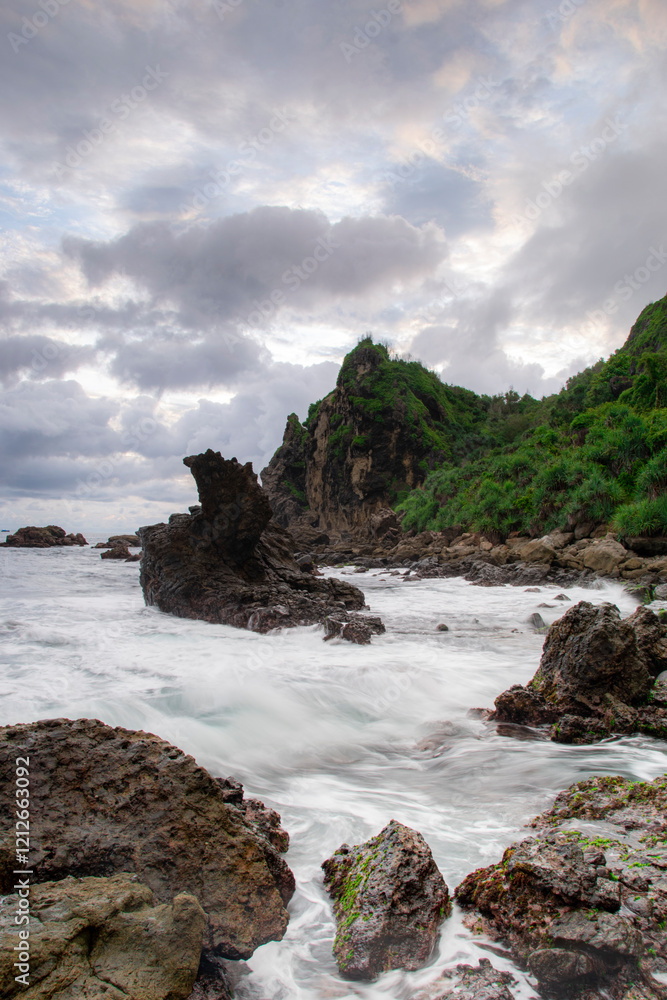 Fototapeta premium Long shutters of waves crashing against the rocks on a beautiful beach in the Special Region of Yogyakarta.