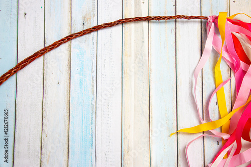 Easter background on wooden planks in pastel colours with Easter whip decorated with many colorful ribbons around a background with space for your text. photo