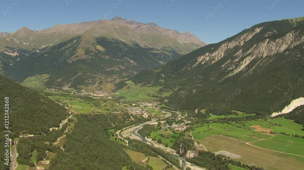 Vue aérienne panoramique d'une vallée et village de montagne en été avec une rivière Vue aérienne panoramique d'une vallée et village de montagne en été avec une rivière