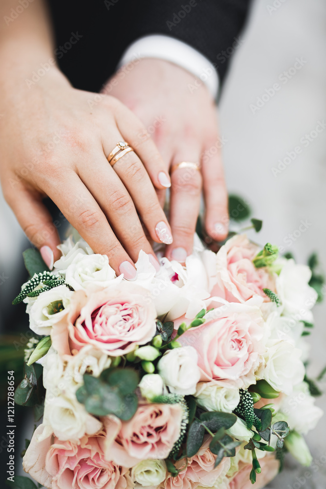 Beautiful young wedding couple posing with bouquet of flowers in hands Beautiful young wedding couple posing with bouquet of flowers in hands