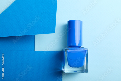 Nail polish in bottle on color background, top view. Space for text photo