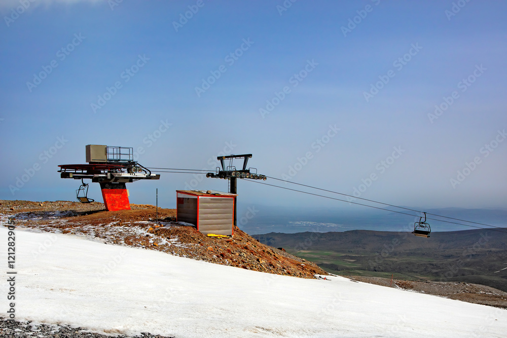 Cable car station overlooks stunning snow-covered landscape under clear blue skies. Copy space.