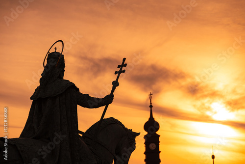 Silhouette of St. Stephen’s statue holding a cross at sunset in Budapest, Hungary. A dramatic and iconic cityscape. Travel to Hungary. photo