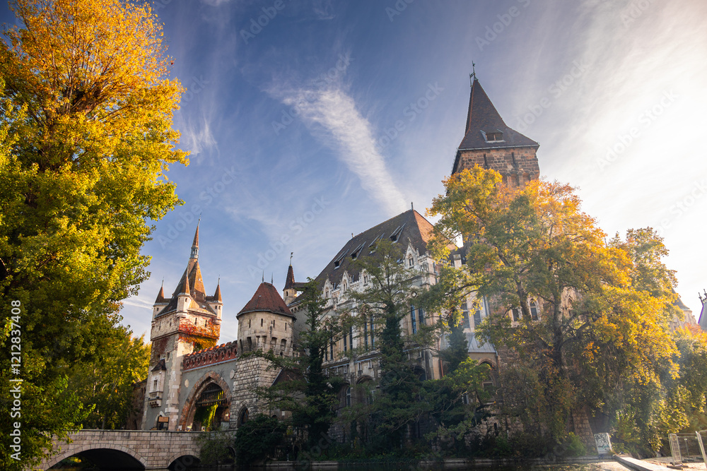 Vajdahunyad Castle from the main city in Budapest surrounded by lush greenery and reflecting in the water. A fairytale-like architectural gem. Travel to Hungary during autumn.