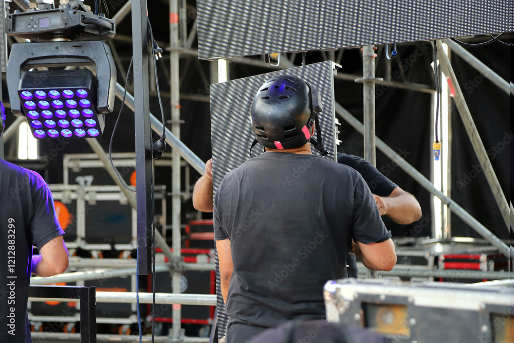 Foto Technicians working on stage assembling giant LED screen panels for rock event