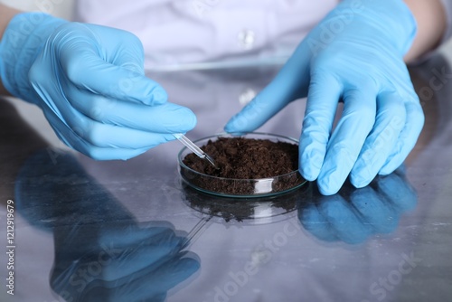 Laboratory testing. Scientist working with soil sample at table, closeup photo