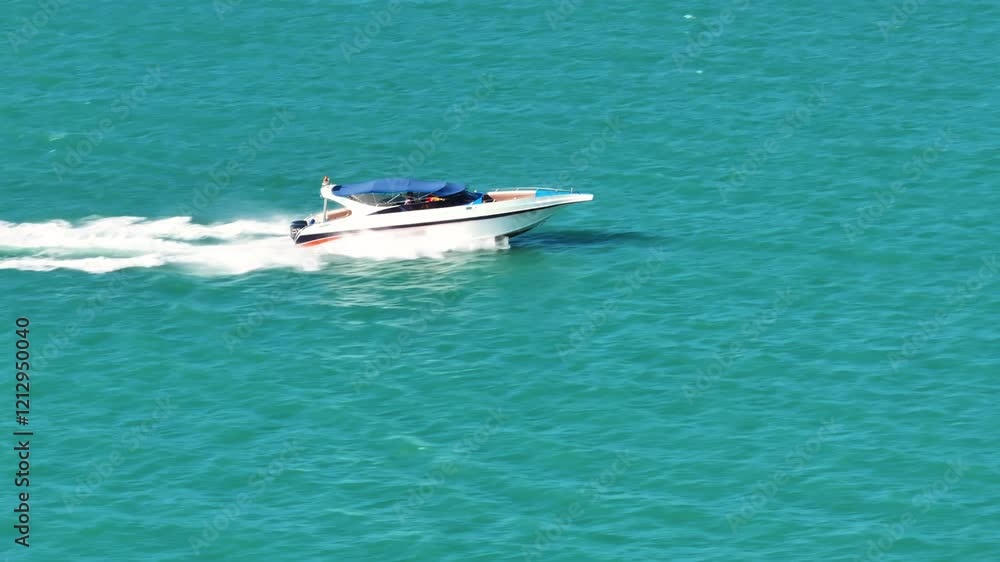 Speeding boat navigates clear turquoise waters in a coastal area during sunny weather Speeding boat navigates clear turquoise waters in a coastal area during sunny weather