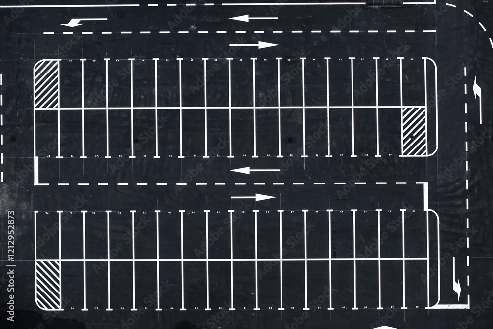 Aerial view of an empty parking lot with white lane markings and directional arrows. Ideal for urban planning, transportation, and parking management industries.