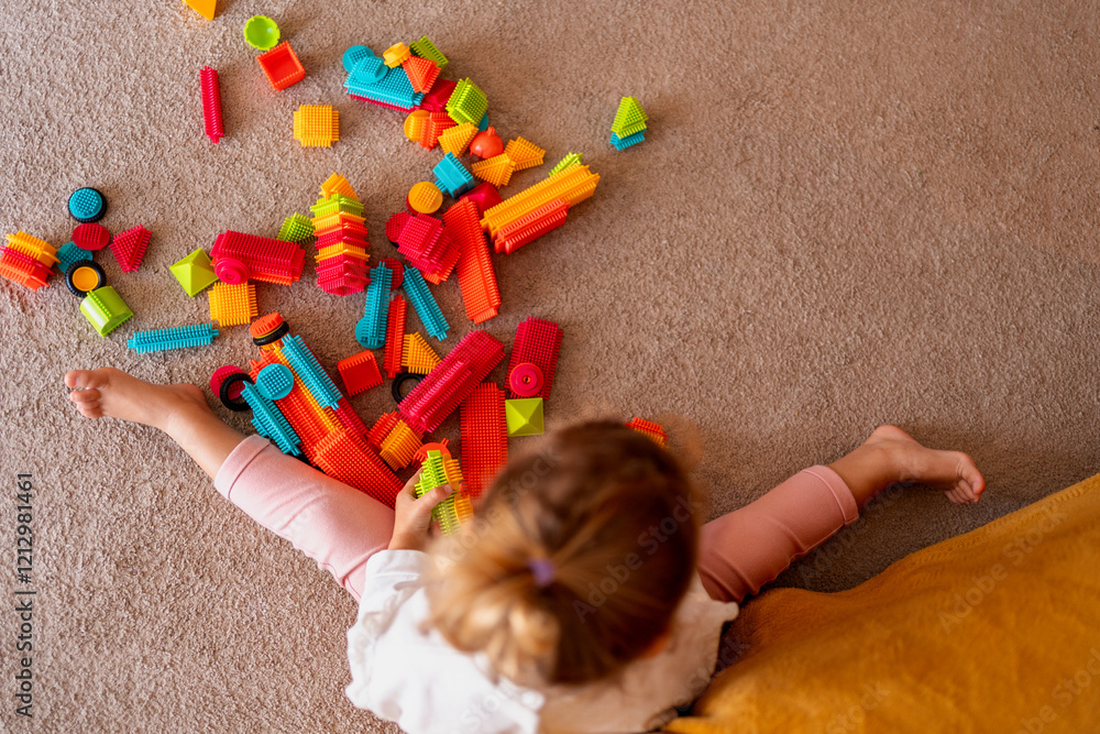 Ταπετσαρία Little girl enjoying creative playtime with colorful bristle blocks, enhancing f
