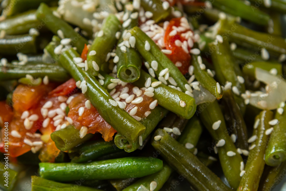 Tzimmes with green beans and tomatoes sprinkled with sesame seeds Jewish dish close-up. Horizontal photo. Tzimmes with green beans and tomatoes sprinkled with sesame seeds Jewish dish close-up. Horizontal photo.