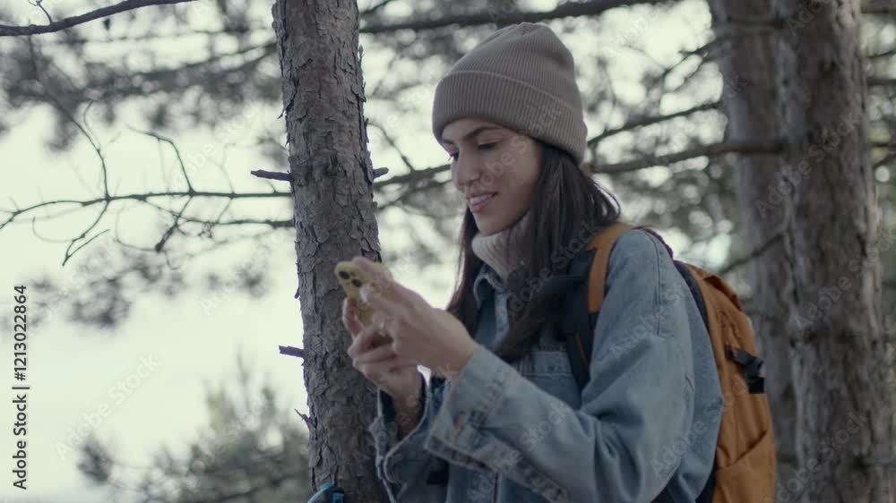 A female hiker is enjoying a day in the forest, using a smartphone for a map. 4k video A female hiker is enjoying a day in the forest, using a smartphone for a map. 4k video