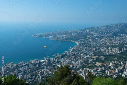 A breathtaking aerial view of Jounieh’s seaside with resorts, boats, and paragliders over the blue Mediterranean. Travel blogs, brochures, and adventure magazines. photo