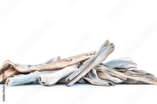 A pile of driftwood, bleached by the sun and sea, rests on a white background. photo