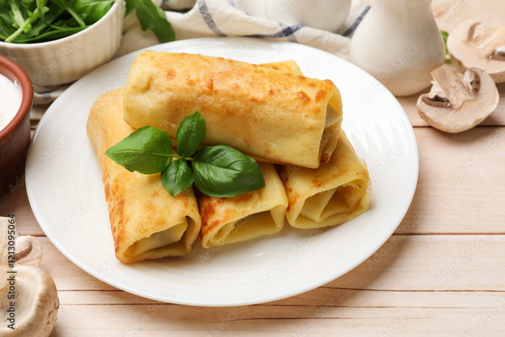 Delicious rolled crepes with basil and mushrooms on wooden table, closeup Delicious rolled crepes with basil and mushrooms on wooden table, closeup
