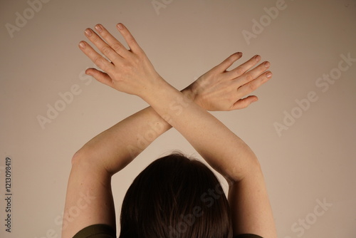 Image of a turned woman closing her eyes on a gray background. Her back is turned, only half of her head is visible. photo