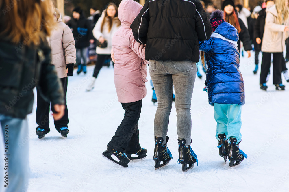 Happy people ice skating on rink in winter outdoors. Photography, portrait, sport and hobby concept. Happy people ice skating on rink in winter outdoors. Photography, portrait, sport and hobby concept.