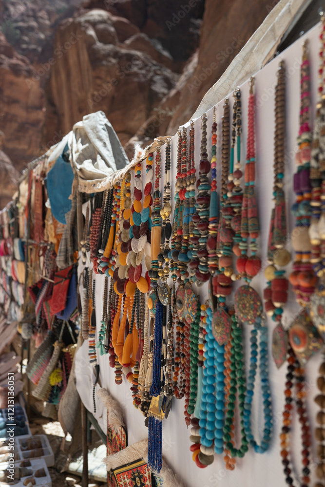 Naklejka premium Ancient Petra’s market street filled with unique Bedouin ornaments, carpets, and fabrics. Travel or cultural tourism promotions, Middle Eastern culture, souvenirs.