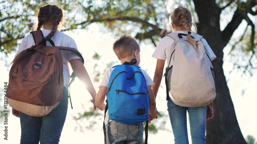 A group of children are standing in the forest with backpacks on their backs. Backpack nature hiking concept. Schoolchildren with backpacks in the park. Children and schoolchildren in the park. A group of children are standing in the forest with backpacks on their backs. Backpack nature hiking concept. Schoolchildren with backpacks in the park. Children and schoolchildren in the park.