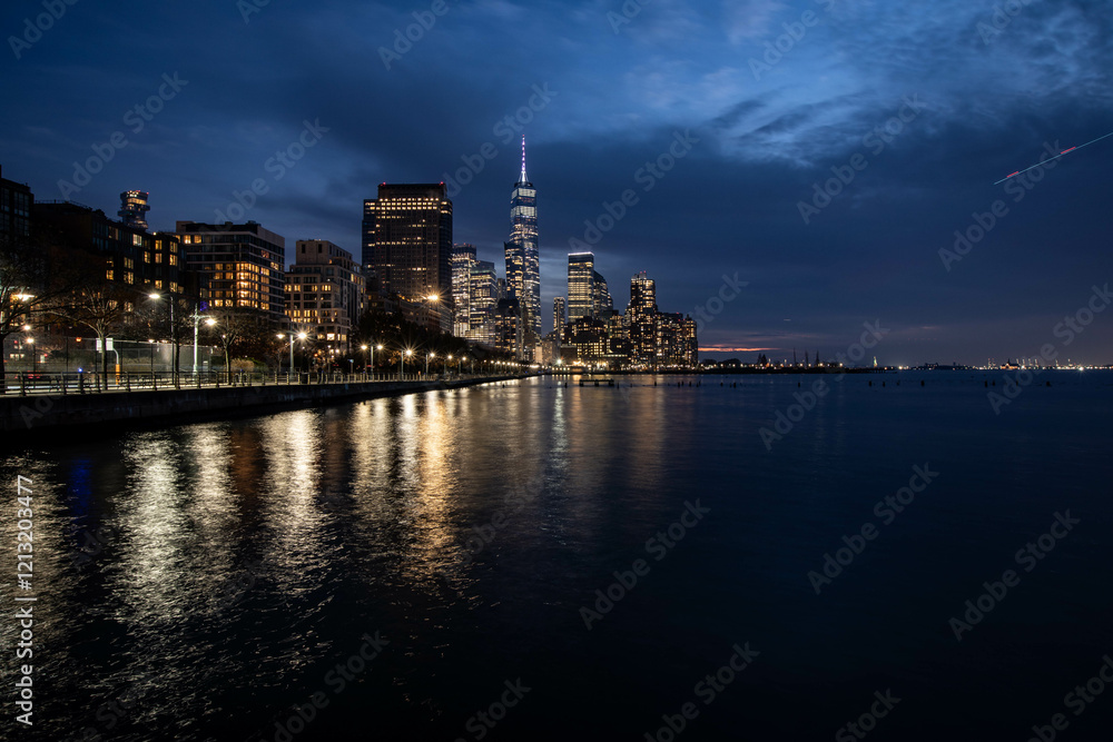 Obraz premium New York Skyline with One World Trade Center in the blue hour, light of the city reflecting in the water of hundson river