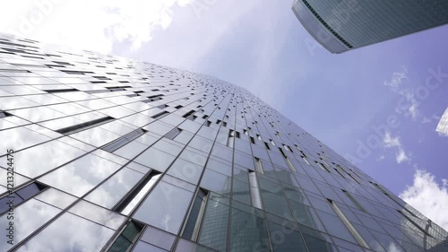This skyscraper has a stunning glass facade under a clear blue sky
