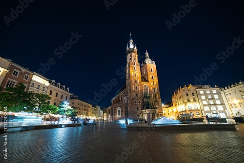 Historic architecture and vibrant nightlife in Krakow's main square at night, showcasing the iconic St. Mary's Basilica photo