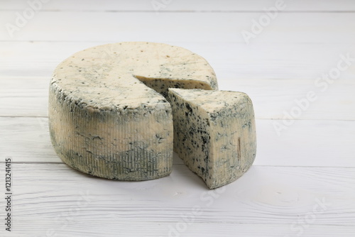 Εκτύπωση καμβά A wheel of blue cheese and a slised piece of cheese on a plate on a white wooden