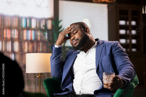 African american worried agent in a lounge reviewing mission briefs, working under pressure to accomplish the mission goals and help with a national safety operation, CIA intelligence agency. photo