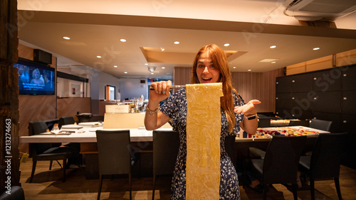 Bild auf Leinwand Mujer emocionada mostrando noodles gigantes en un restaurante elegante