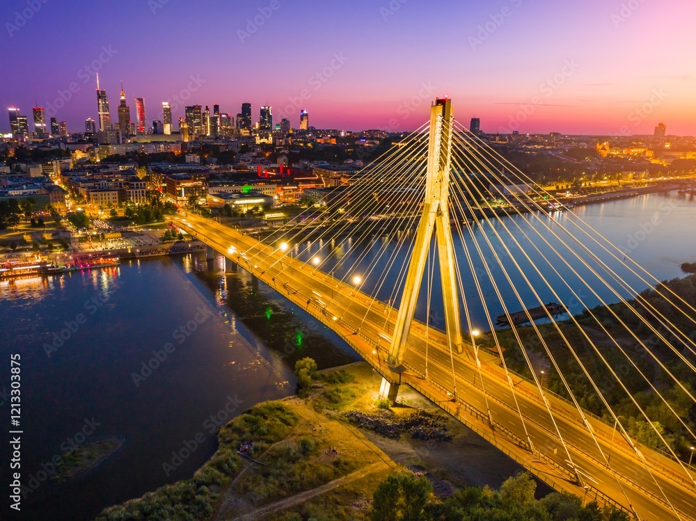 Obraz premium Beautiful sunset over Warsaw showcasing the illuminated bridge and city skyline