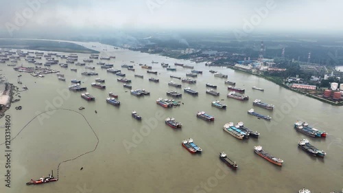 Aerial view of Container ships, barges, and vessels navigating from the Bay of Bengal to the Karnaphuli River, showcasing the dynamic flow of maritime trade and commerce