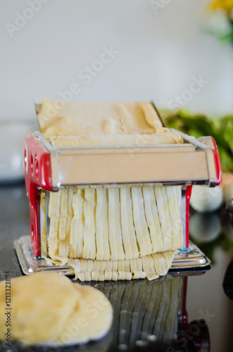 The fresh pasta and machine on kitchen table home made