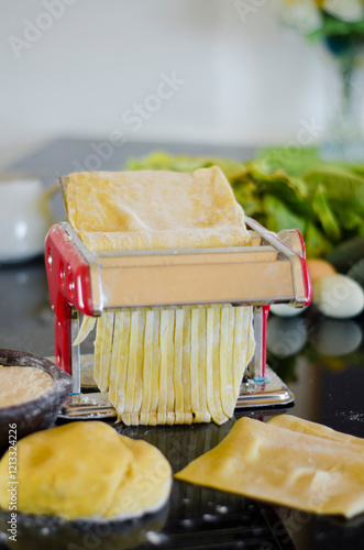 The fresh pasta and machine on kitchen table home made