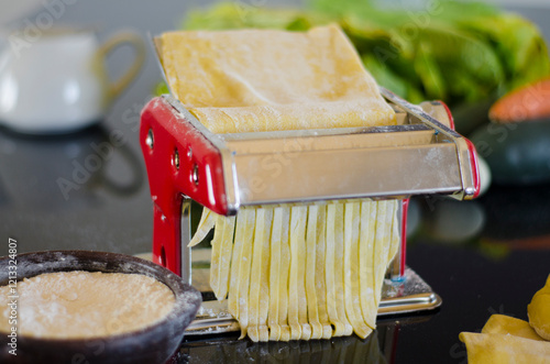 The fresh pasta and machine on kitchen table home made