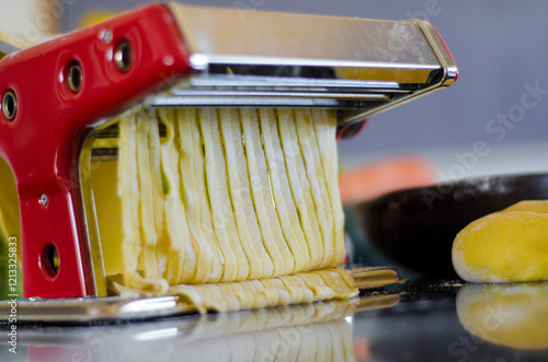 The fresh pasta and machine on kitchen table home made