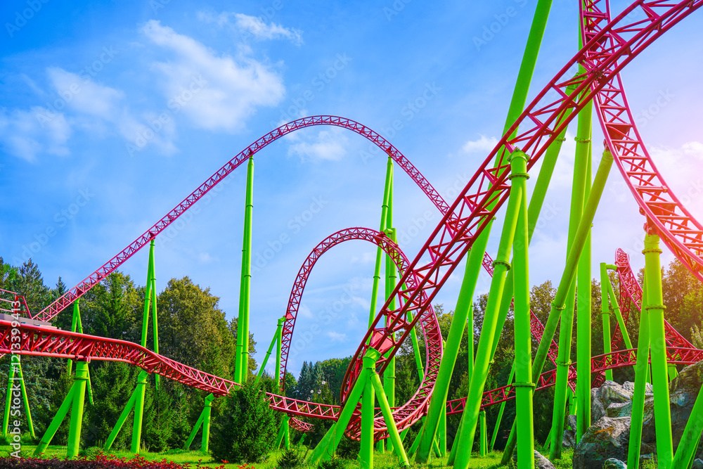 General view of the summer amusement park and the twists and turns of the roller coaster in the city park General view of the summer amusement park and the twists and turns of the roller coaster in the city park