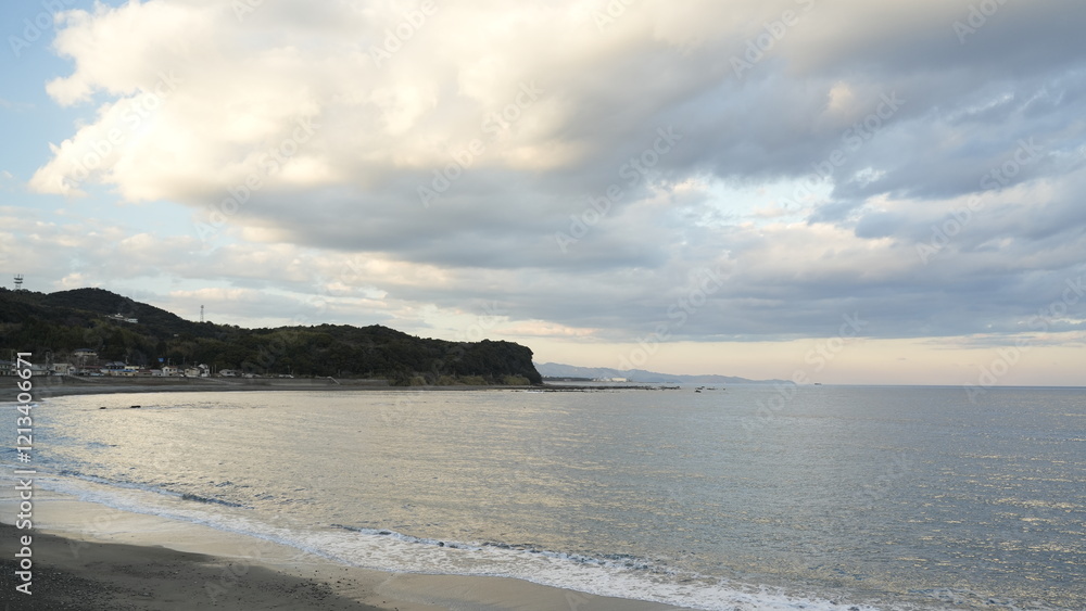 Fototapeta premium 夕暮れ時の海岸を散歩