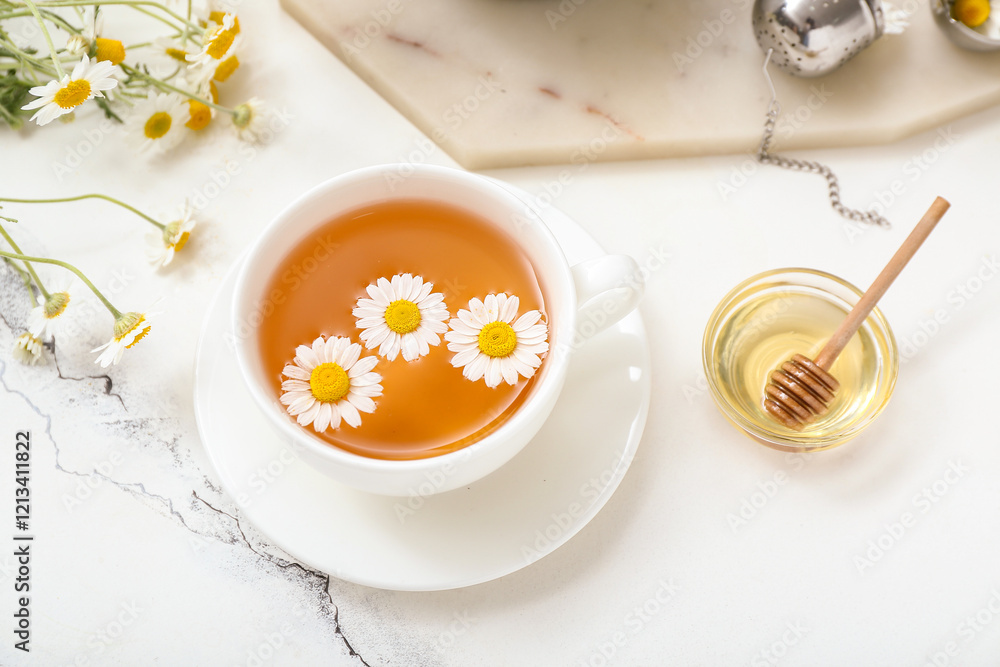 Cup of hot chamomile tea and honey on white marble background Cup of hot chamomile tea and honey on white marble background