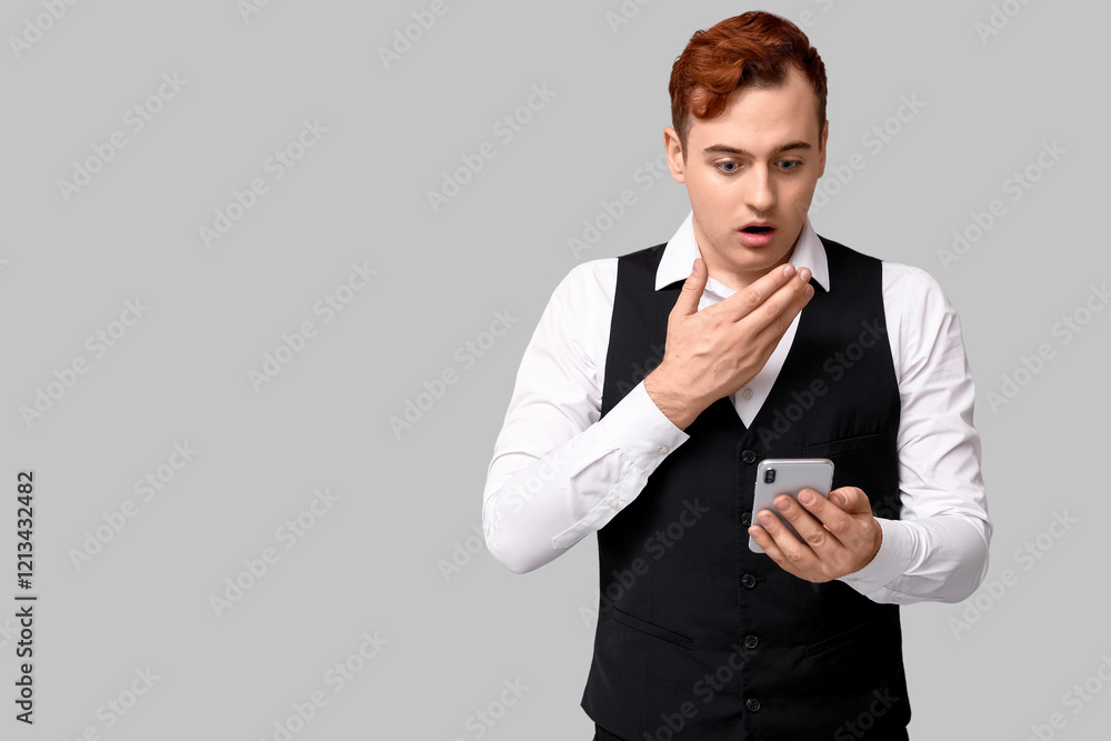 Shocked young man with mobile phone on grey background. Black Friday sale Shocked young man with mobile phone on grey background. Black Friday sale