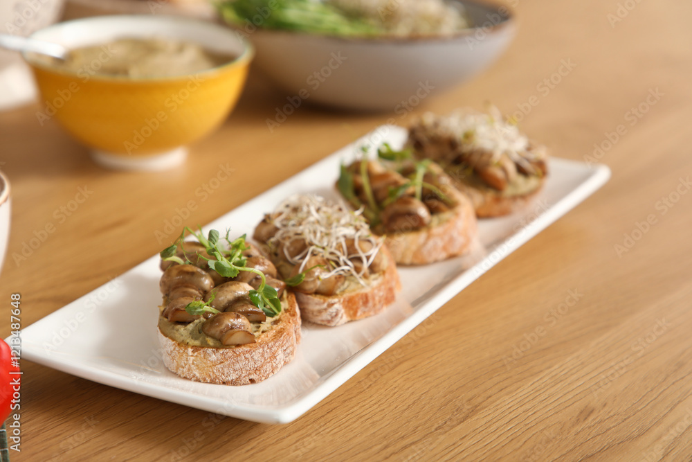 Plate with tasty vegan bruschettas on table in kitchen, closeup Plate with tasty vegan bruschettas on table in kitchen, closeup