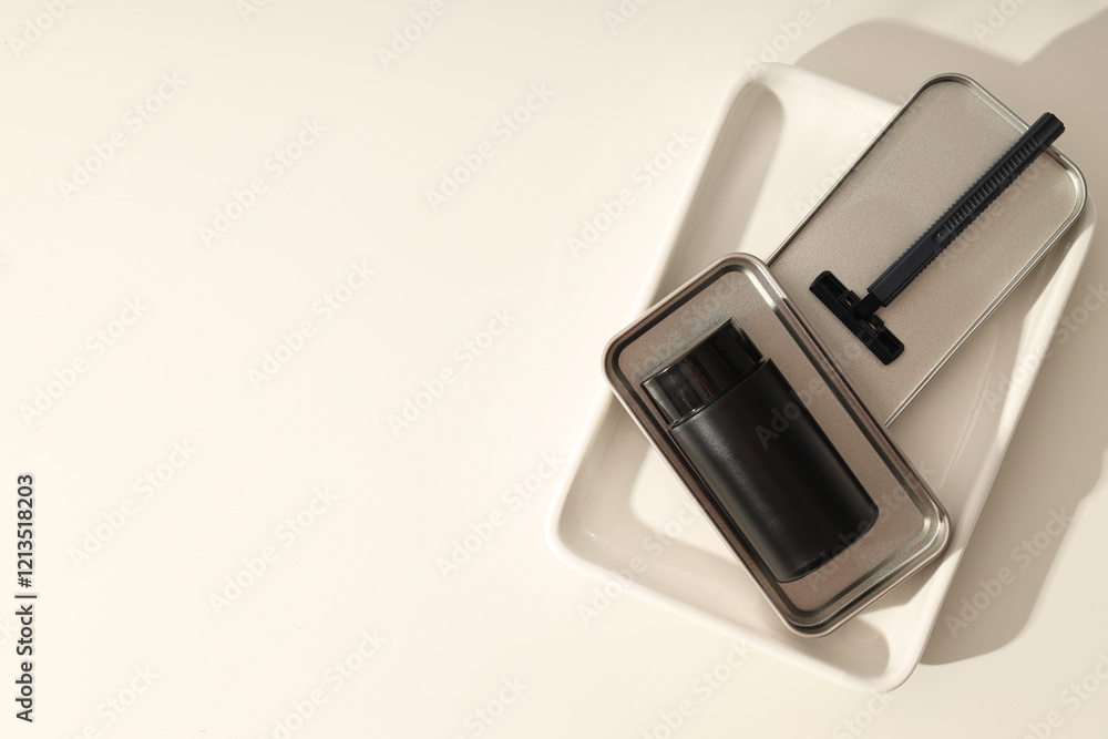 Black bottle and razor on white background, space for text Black bottle and razor on white background, space for text