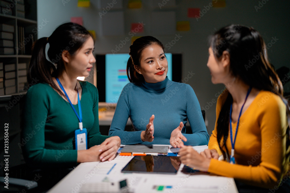 Fototapeta premium Asian businesswomen having meeting using tablet in office at night