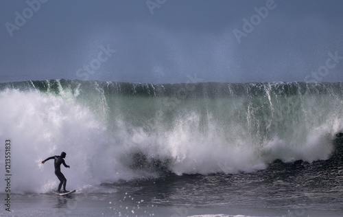 Surfer riding large wave on surfboard  photo