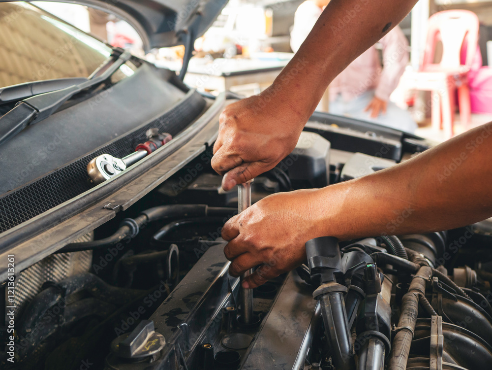 Obraz premium Close up Car Mechanic man hands repairing car auto repair shop. Man hands fixing machinery vehicle mechanical service. open vehicle hood checking up auto mobile. Vehicle Car maintenance engineer.