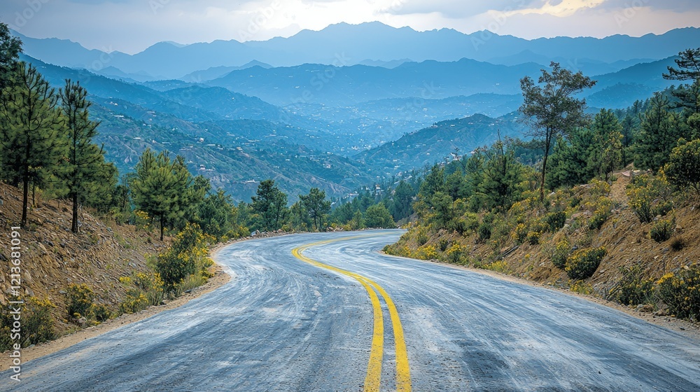 Naklejka premium Winding Mountain Road Through Blue Hues Landscape