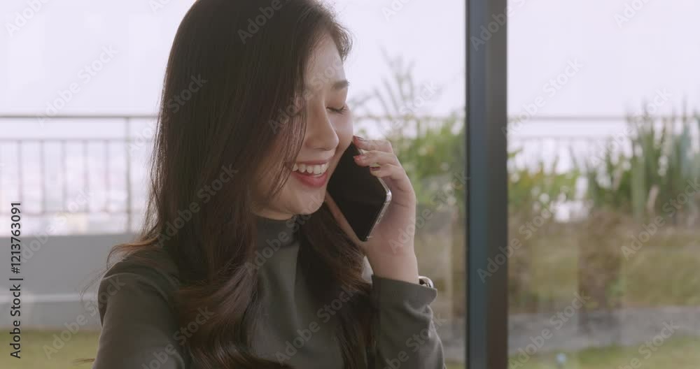 woman uses her phone while sitting at work in a working space. woman uses her phone while sitting at work in a working space.