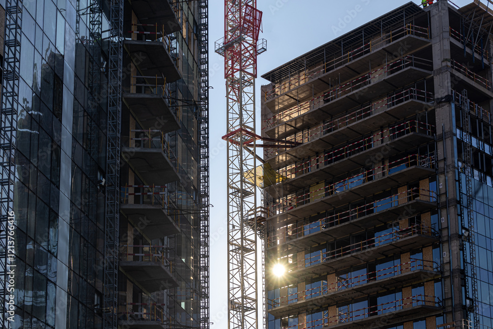 Sunrise over an urban construction site with cranes and buildings in development, showcasing growth and industrial progress. Industrial residential construction industry.