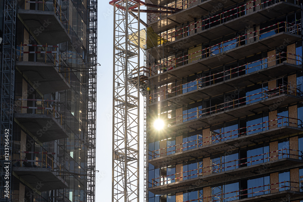 Sunrise over an urban construction site with cranes and buildings in development, showcasing growth and industrial progress. Industrial residential construction industry.